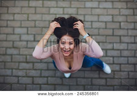 Young Smiling Teen Girl Looking At Camera. Shot From Above.
