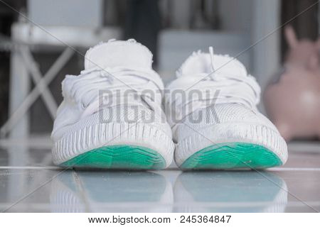 Old White Shoes Used To Play Sepak Takraw. On The Tile Floor.
