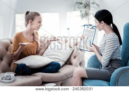 Not My Fault. Nervous Girl Keeping Palms Up And Acquitting Herself While Psychologist Showing Her A 