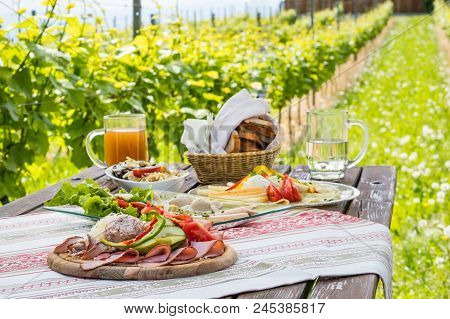 Brettljause, Traditional Cold Plate With Meat, Cheese, Fish, Vegetable, Bread And Drinks On Wooden T