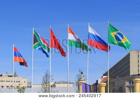 Flags Of Brics Countries On A Sunny Summer Morning Against Blue Sky