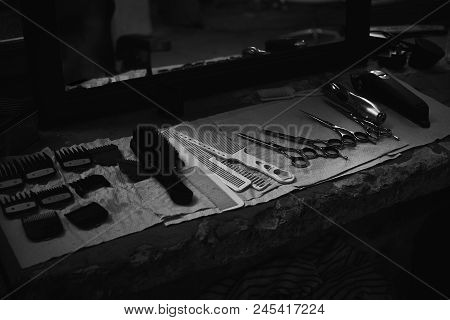 The Tools Of A Barber On The Desktop In Front Of The Mirror .black And White Photo Of Hairdresser To