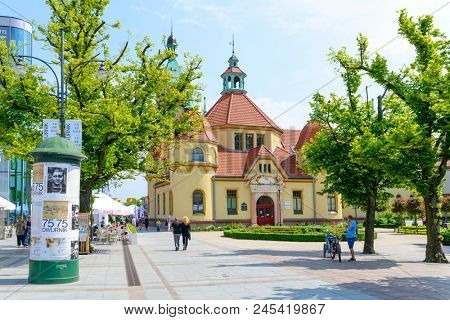 SOPOT - MAY 26: Tourists enjoy the sunny weather and walking in front of the balneological clinic with a lighthouse on 26 May 2018 in Sopot, Poland. The building was built in 1903.
