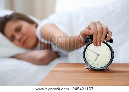 Sleepy Young Woman Stretching Hand To Ringing Alarm Willing Turn It Off. Early Wake Up, Not Getting 
