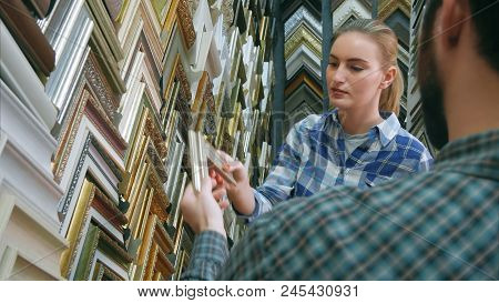 Male Worker Chatting With Customer About Picture Frame Details In