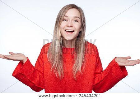 Indoor Shot Of Amazed Pretty Blond Caucasian Female Exclaims And Gestures Actively, Expresses  Great