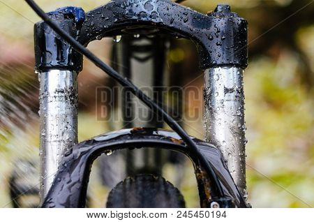 Washing Dirty Mountain Bike Suspension Fork After Riding In Bad Weather. Wet, Dirt And Oil Stains On