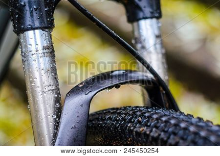 Washing Dirty Mountain Bike Suspension Fork After Riding In Bad Weather. Wet, Dirt And Oil Stains On