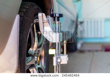 Car On Stand With Sensors On Wheels For Wheels Alignment Camber Check In Workshop Of Service Station