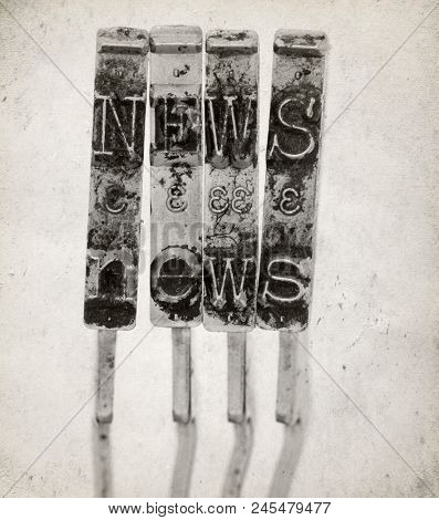The word NEWS ith old typewriter hammers macro image on old paper 