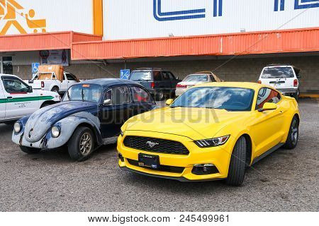 Palenque, Mexico - May 22, 2017: Yellow Muscle Car Ford Mustang And Old Car Volkswagen Beetle In The
