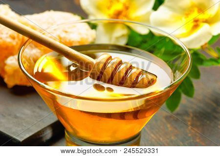 Honey With Wooden Honey Dipper On Wooden Table