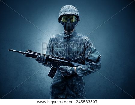 Soldier agent in a dark room with arms on his hand and gas mask