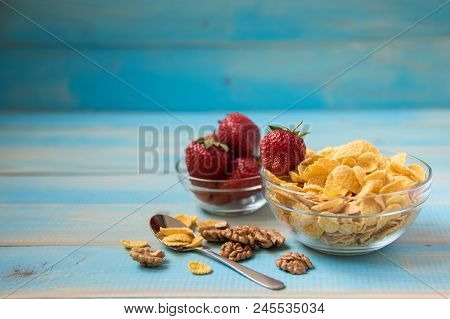 Tasty Cornflakes With Walnut And Strawberries In Glass Bowl On Blue Background. Corn Flakes, Copy Sp