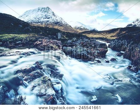 Pools And Majestatic Waterfalls Belllow Snowy Mountains. Blue Water Mirrorong Blue Cloudy Sky
