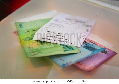 National Currency Of Thailand Baht With A Cash Check Lying On The Table. Change Thb And Check After 