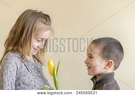 The Little Gentleman Gives The Girl A Bunch Of Flowers. The Little Boy Gives Yellow Tulip