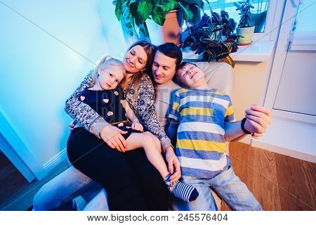 Parents And Kids Sitting On The Sofa And Having Fun At Home. Smiling A Lot Close Up View
