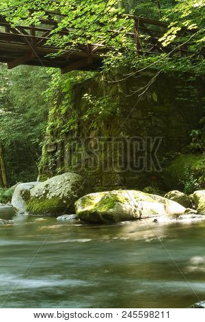 A Footbridge Over A River In A Forest.  Great Smoky Mountains National Park, Usa.