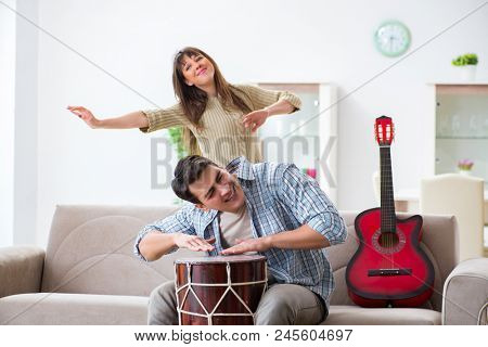 Young family singing and playing music at home