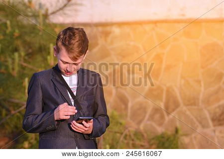 A Boy With A Smartphone Reads A Message In A Smartphone