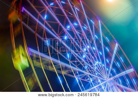 Carnival Ride Showing A Spinning Ferris Wheel In Action- Long Exposure Shot.