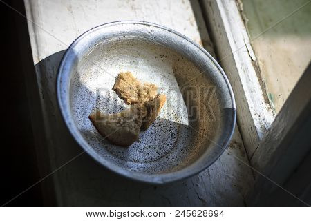 The Old Window From It Drops Sunlight. On The Window An Old Aluminum Bowl In It Small Pieces Of Brea
