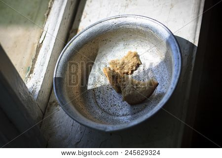 The Old Window From It Drops Sunlight. On The Window An Old Aluminum Bowl In It Small Pieces Of Brea