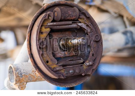 Dirty Used Drum Brake Mechanism Of Car Wheel In Garage.