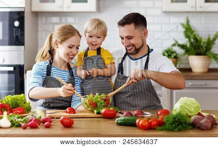 Appy Family With Child  Preparing Vegetable Salad At Home