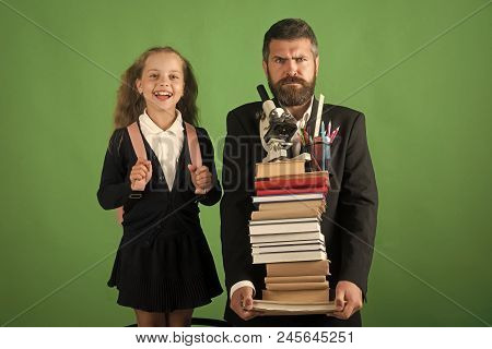 Home Schooling And Back To School Concept Kid And Dad Hold Pile Of Books With School Supplies. Girl 