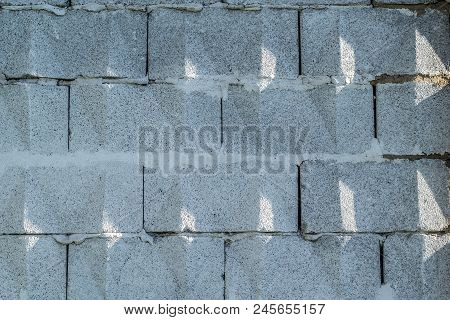 Background, Wall Of Large Gray Brick Blocks With Triangular Patterns And Sun Shadows