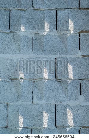 Background, Wall Of Large Gray Brick Blocks With Triangular Patterns And Sun Shadows