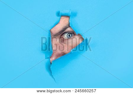 Spy Eye Watching Through Hole. Spy. Supervision. Eye Looking Through Hole In Paper. Man Looking Thro