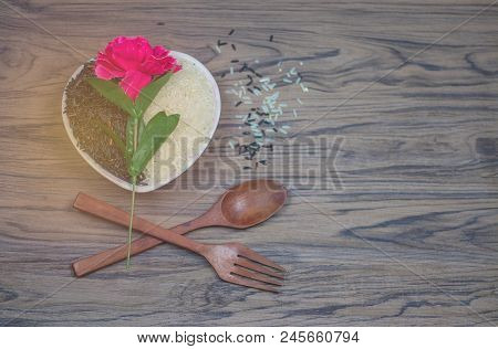 On Seletive Focus Of Heart-shaped Cup That Put Rice Berry & Flowers Pink Paste Above With Spoon And 