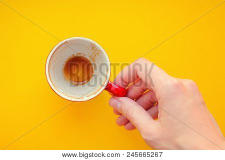 Woman Holding An Empty Cup Of Coffee On Yellow Background Closep Top View