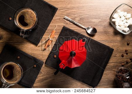 Top View On Mugs Of Coffee On Black Napkins Near The Red Coffee Maker.
