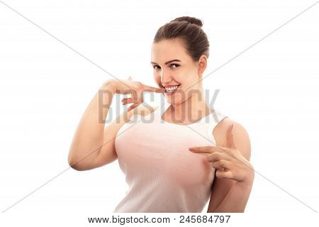 Young Woman Shows Her Big Fake Breasts On White Background