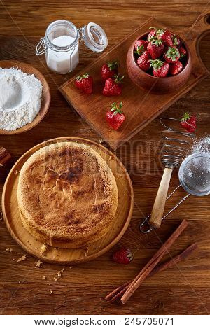 Top View Raw Ingredients For Cooking Strawberry Pie Or Cake On Wooden Table: Eggs, Sugar And Strawbe