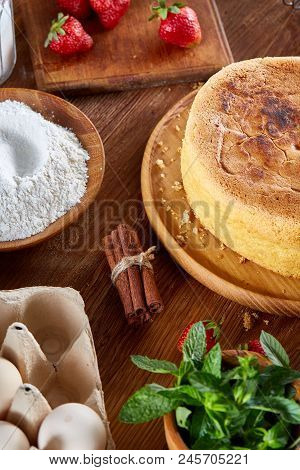 Baking Background With Strawberry Tart Covered With Whipped Sour Cream Surrounded By Organic Ingredi