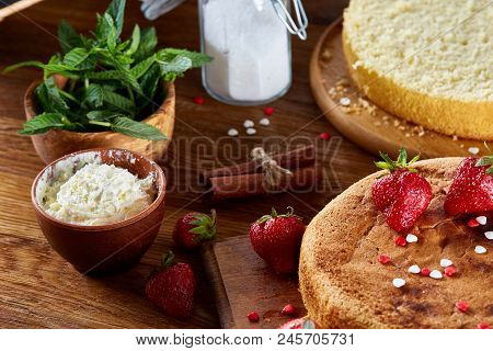 Baking Background With Strawberry Tart Covered With Whipped Sour Cream Surrounded By Organic Ingredi
