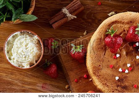 Baking Background With Strawberry Tart Covered With Whipped Sour Cream Surrounded By Organic Ingredi