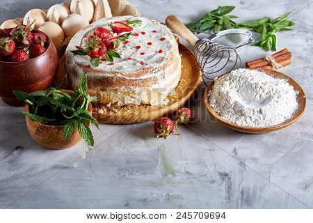 Strawberry Tart Covered With Whipped Sour Cream Surrounded By Organic Ingredients Over White Backgro