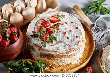 Strawberry Tart Covered With Whipped Sour Cream Surrounded By Organic Ingredients Over White Backgro