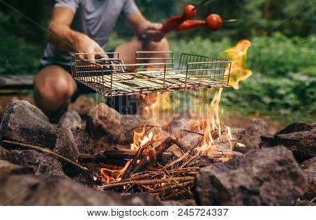 Summertime Leisure Concept Image: Man Cooks A Vegetabels On Campfire