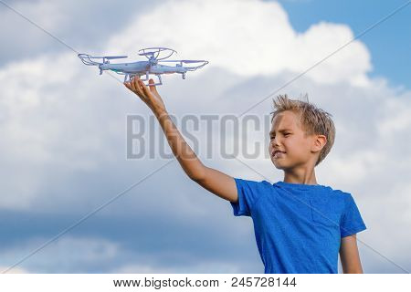 Child Playing With Drone Outdoors Against Blue Sky