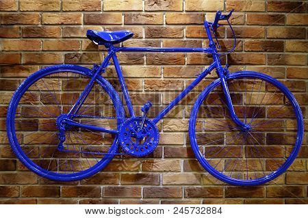 Blue Bicycle On A Brick Wall. Unusual Beautiful Pink Tones.