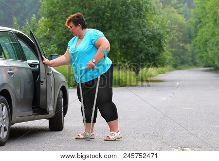 Disabled woman upgoing from a car. Transportation and travel for handicapped people.