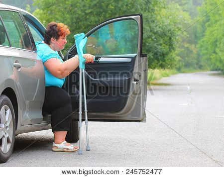 Disabled woman upgoing from a car. Transportation and travel for handicapped people.