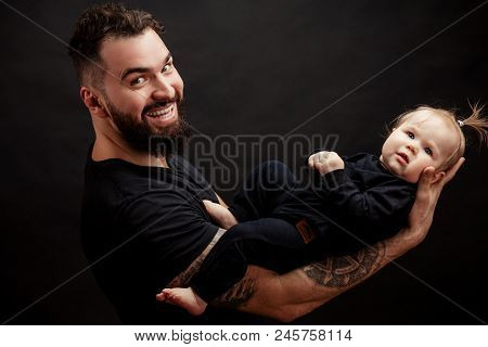 Handsome Father Holding Lovely One Year Old Infant Girl With Beautiful Appearence Lying On His Tatto